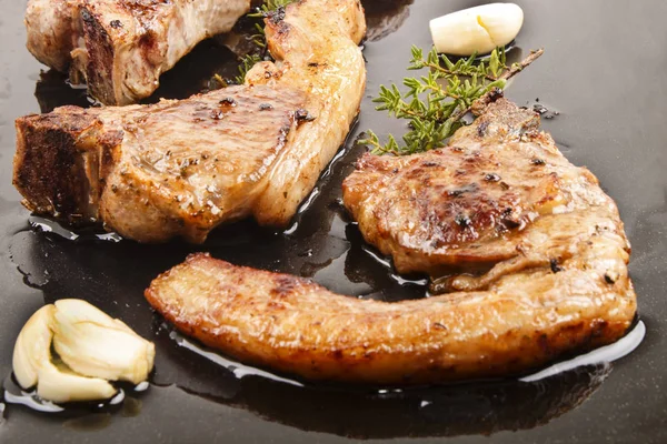 Grilled lamb chop with thyme and garlic on a roasting tray — Stock Photo, Image