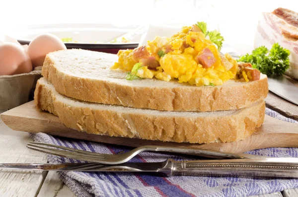Scrambled eggs with bacon on a slice of bread — Stock Photo, Image
