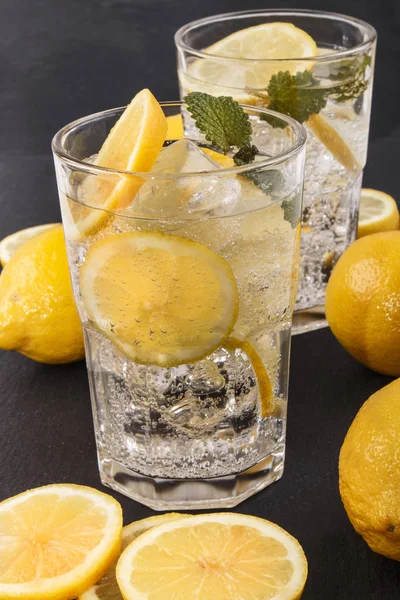 Sparkling mineral water with ice and lemon slices — Stock Photo, Image