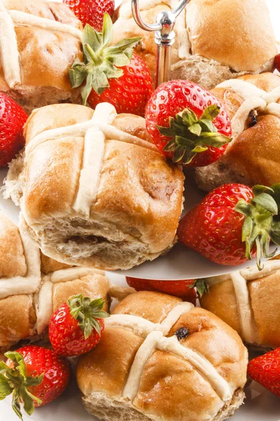 Hot cross buns and sweet strawberries on a cake stand — Stock Photo, Image