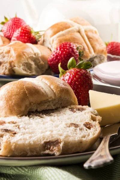 Petits pains croisés chauds et fraises sucrées sur une assiette — Photo