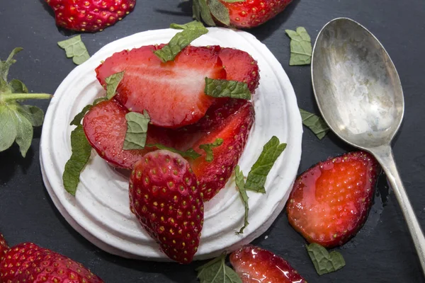 Pavlova s jahodami řezy, slazené a citronovou mátou — Stock fotografie