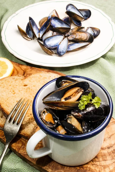 Mussels with garlic and butter sauce in a blue and white enamel — Stock Photo, Image