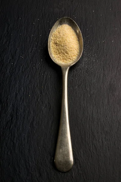 Garlic granulated on a metal spoon — Stock Photo, Image