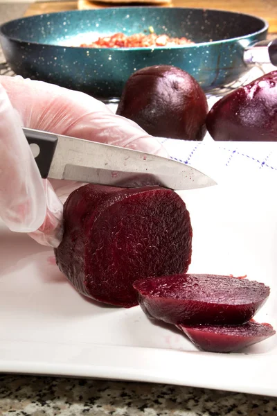 Beetroot is cut from a female chef on a porcelain plate in slice — Stock Photo, Image