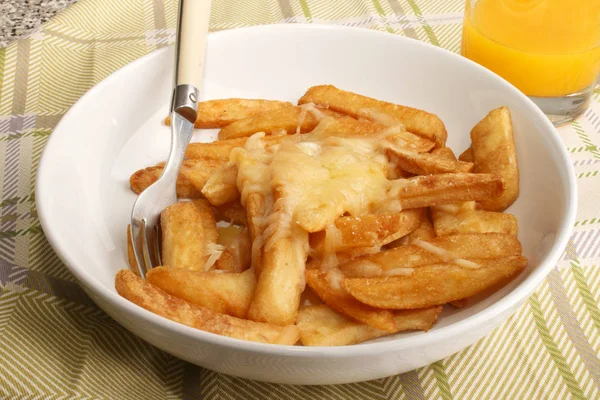 Pommes frites med smält irländsk cheddar ost och apelsinjuice — Stockfoto