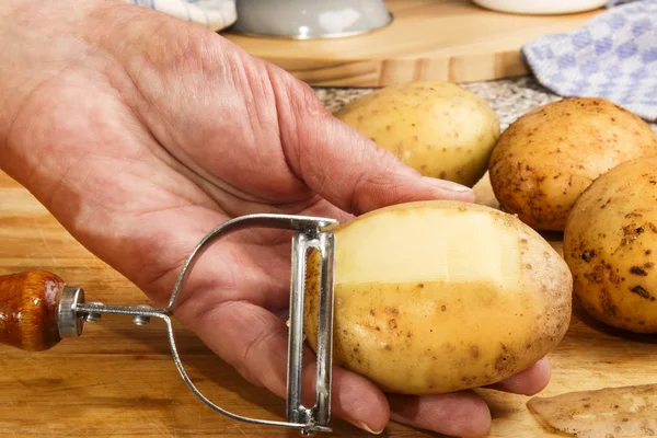 Femme chef épluche les pommes de terre — Photo