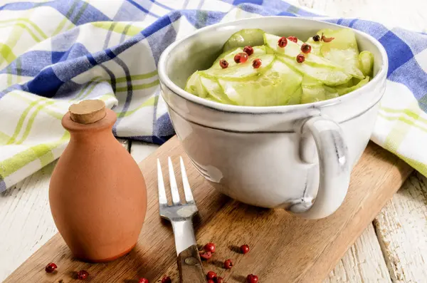 Komkommer salade in een grijze cup op houten plank — Stockfoto