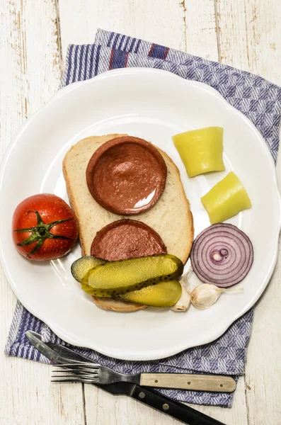 Linguiça queimada grelhada uma fatia de pão — Fotografia de Stock