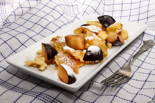 Kaiserschmarrn s švestky posypané moučkovým cukrem — Stock fotografie