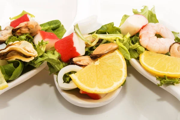 Három porcelán kanalat a tenger gyümölcsei saláta — Stock Fotó