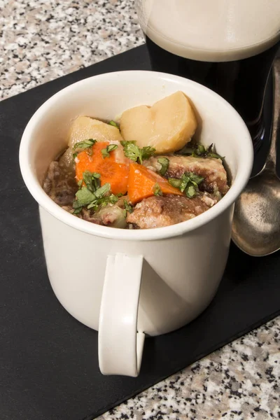 Dublin coddle in a mug on slate — Stock Photo, Image