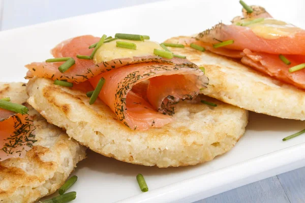Fijn restaurant, kleine aardappel pannenkoeken met plakjes zalm en dille — Stockfoto