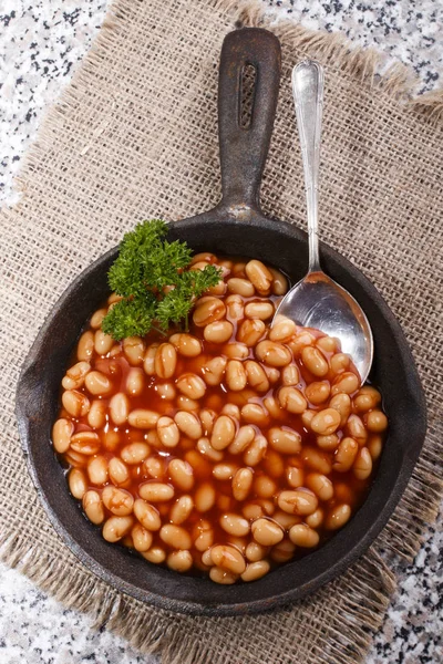 Warm baked beans in tomato sauce served in a cast iron pan — Stock Photo, Image