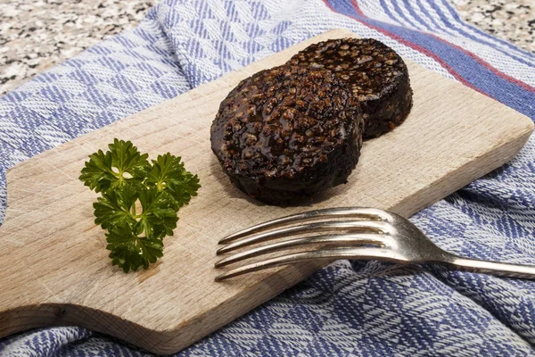 Grilled irish black pudding made with oatmeal on a wooden board — Stock Photo, Image