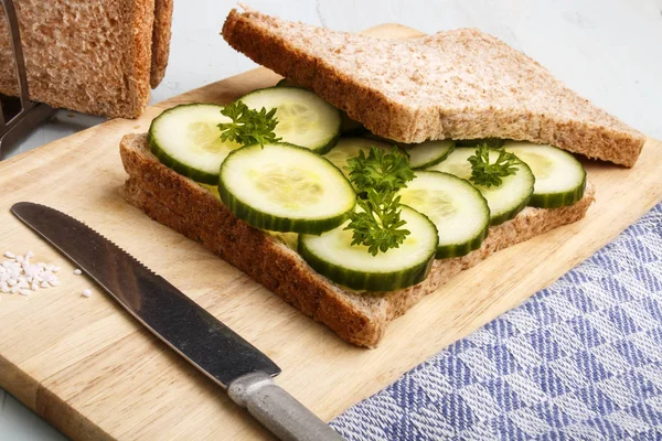 Voorbereiding van een bruin toast sandwich met biologische komkommer — Stockfoto