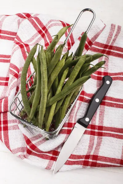 Green beans in a metal basket and a knife to cut — Stock Photo, Image