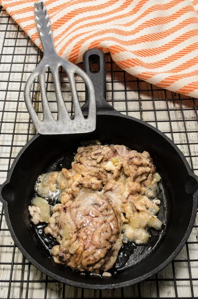 Gegrilde varken hersenen met ui in een pan — Stockfoto