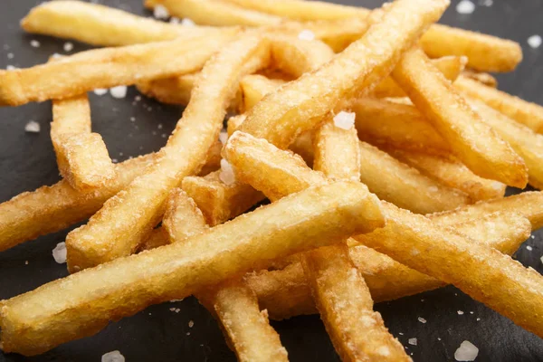 Batatas fritas com sal grosso na ardósia — Fotografia de Stock