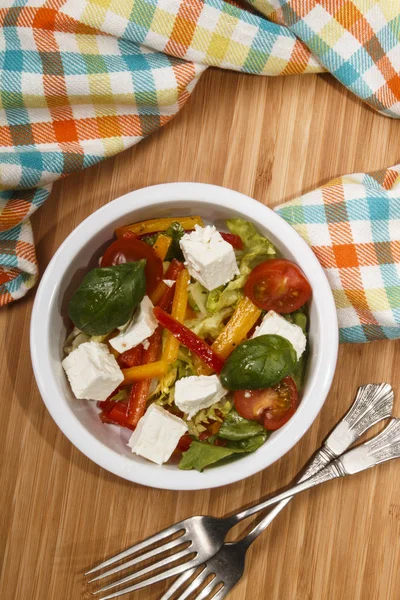 Середземноморський салат з червоно-жовтими смужками паприки, козячим ч — стокове фото