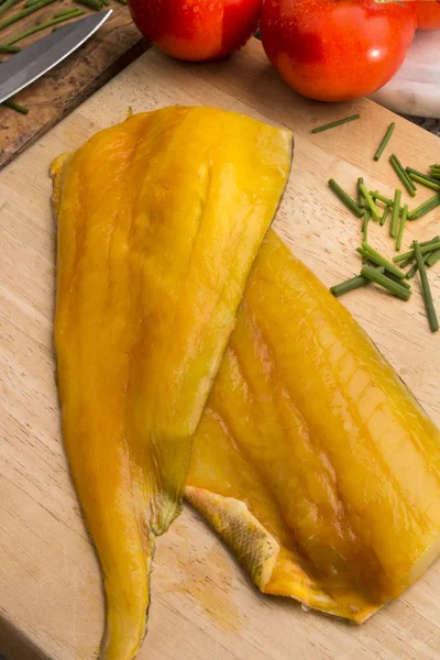 Smoked haddock and tomato on a wooden board — Stock Photo, Image