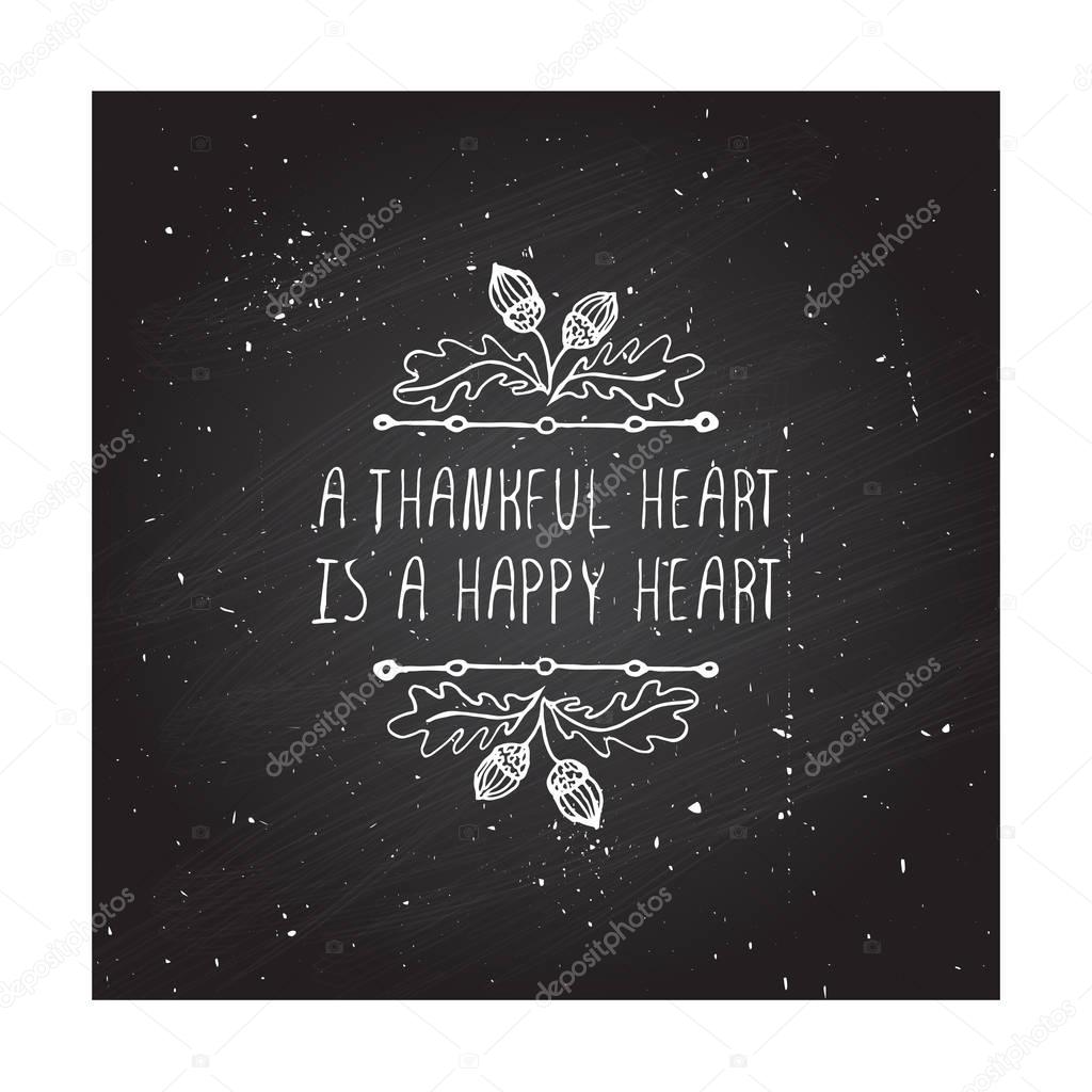 Handdrawn thanksgiving label with acorns and text on chalkboard background. A thankful heart is a happy heart.