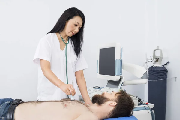 Médico examinando paciente con máquina de ultrasonido — Foto de Stock