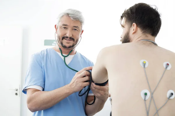 Portrait du médecin mesurant la pression artérielle du patient en hospice — Photo