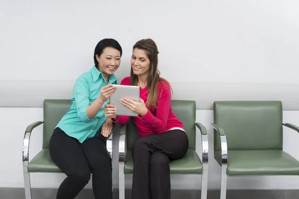 Χαμογελώντας ασθενείς που χρησιμοποιούν ψηφιακή δισκίο ενώ κάθεται στο νοσοκομείο — Φωτογραφία Αρχείου