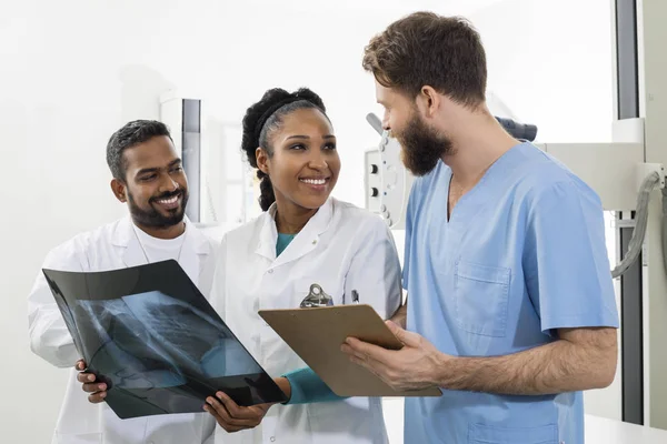 Professionnels médicaux avec radiographie thoracique et presse-papiers à l'hôpital — Photo