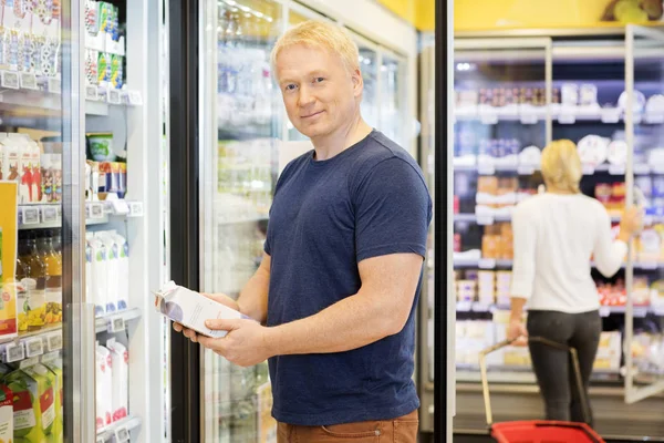 Retrato del cliente sosteniendo el paquete del jugo en la tienda de comestibles — Foto de Stock
