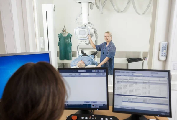 Radiologista Tomando Pacientes Xray Enquanto Colega Usando Computador — Fotografia de Stock