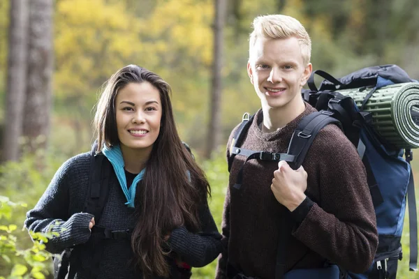 Retrato de casal com mochilas na floresta — Fotografia de Stock