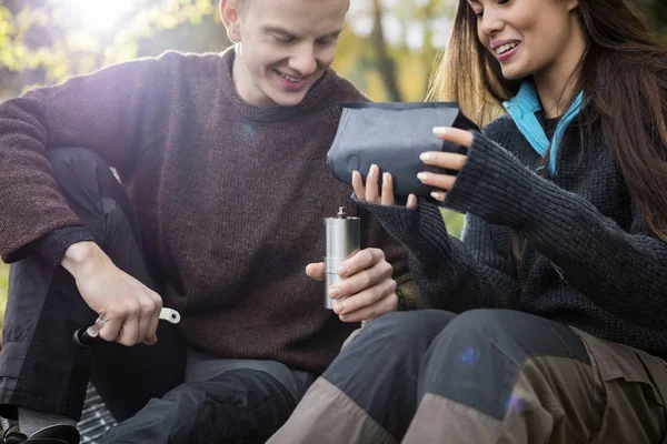 Kvinna som häller kaffe i kvarnen innehas av Man — Stockfoto