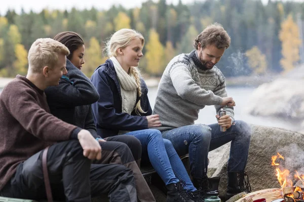 Vänner tittar Man slipning kaffe på campingplats — Stockfoto