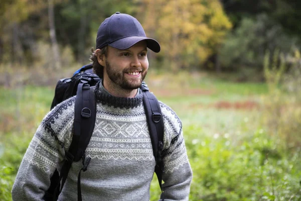 Hombre sonriente con mochila Senderismo en el bosque — Foto de Stock