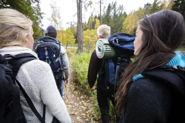 Senderistas con mochilas caminando por sendero forestal —  Fotos de Stock