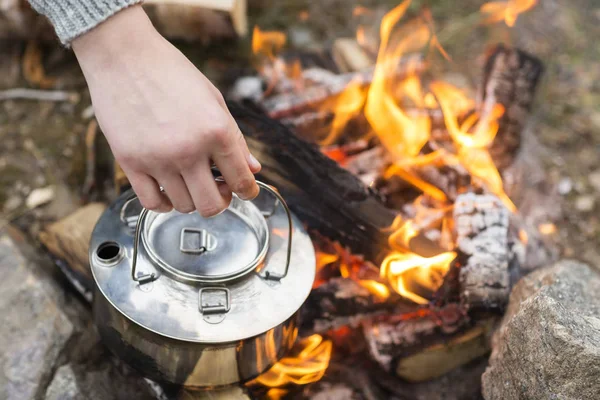 Nahaufnahme von Hand hält Wasserkocher über Lagerfeuer — Stockfoto