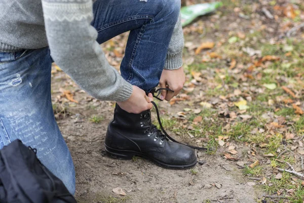 田舎で靴紐を結ぶ男性ハイカー — ストック写真