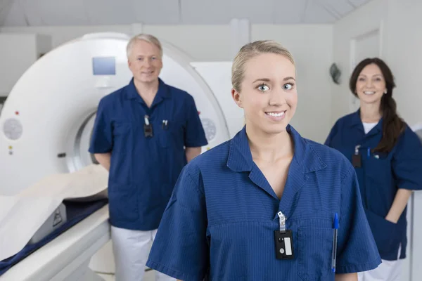 Sonriente profesional médico con colegas de pie por resonancia magnética Mac —  Fotos de Stock