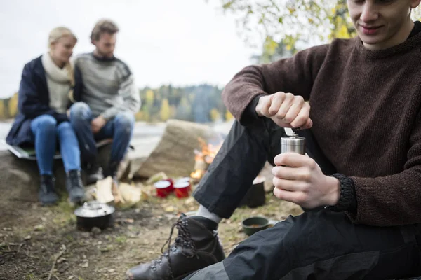 Mann mahlt Kaffee mit Freunden auf Campingplatz — Stockfoto