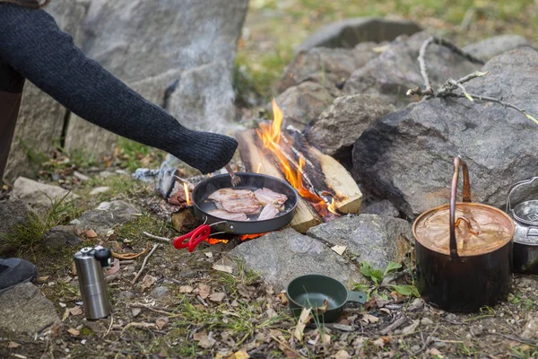 Mujer cocinando comida sobre hoguera en el camping —  Fotos de Stock