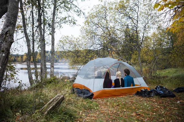 Amis se détendre dans la tente sur le bord du lac — Photo