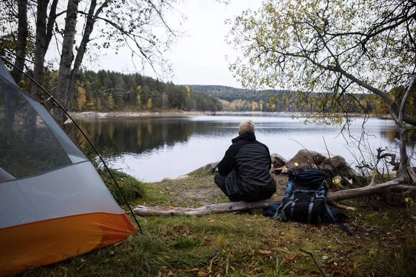 Hombre excursionista disfrutando de la vista del lago en el camping —  Fotos de Stock