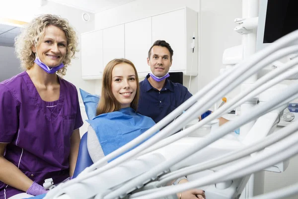 Glimlachend patiënt met tandartsen In kliniek — Stockfoto
