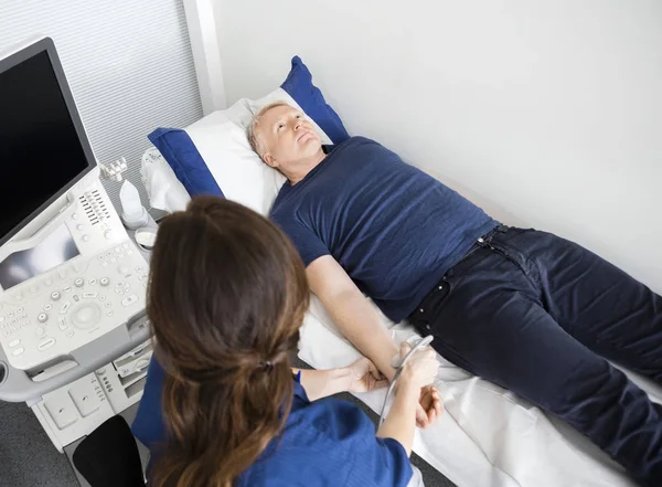 Medico che utilizza sonda ad ultrasuoni sul polso dei maschi in ospedale — Foto Stock