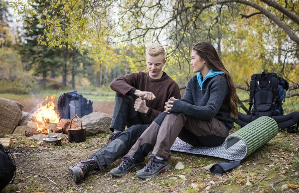 Frau beobachtet Mann beim Kaffeemahlen beim Zelten im Wald — Stockfoto