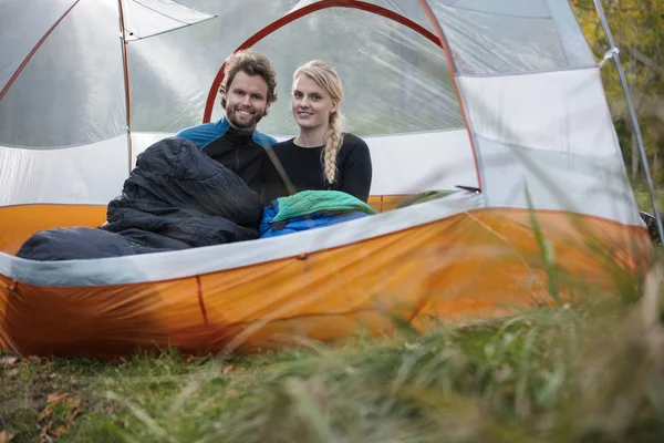 Feliz jovem casal relaxando na tenda na floresta — Fotografia de Stock