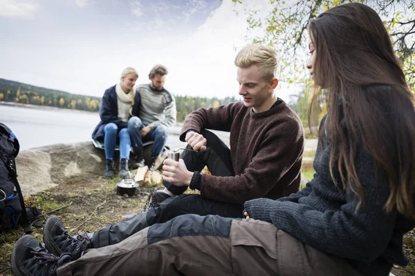 Par slipning kaffe med vänner under Camping — Stockfoto