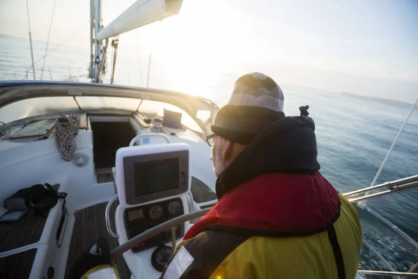 Mann blickt auf Navigationsbildschirm auf Segelboot — Stockfoto